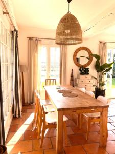 a dining room with a wooden table and chairs at Maison OHANZIA Villefranque in Villefranque