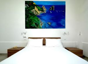 a bedroom with a bed with a large painting on the wall at Pompei Comfort Room in SantʼAntonio Abate