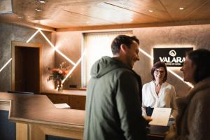 a man and a woman standing at a cash register at VALARA Alpine Art Hotel in Tux
