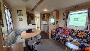 a living room with a couch and a table in a caravan at Meadows nook in Clitheroe
