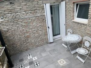 a patio with a table and chairs and a brick wall at Casa Andrean PT Lido Venezia in Venice-Lido
