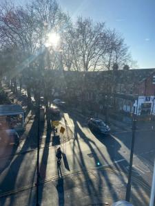 a person walking down a city street with the sun shining at Stylish Modern Flat in Doncaster Centre in Doncaster