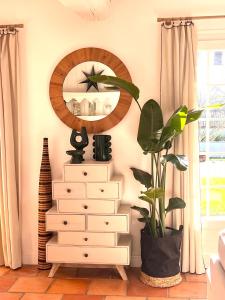 a dresser with a mirror and a plant in a room at Maison OHANZIA Villefranque in Villefranque
