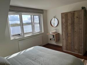 a bedroom with a bed and a large window at Huisje Scheldevallei in Temse