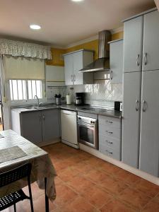 a kitchen with stainless steel appliances and a table at La Casa del Camaleon in Chipiona