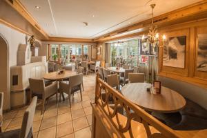 a restaurant with tables and chairs and windows at Appartements Lorenzoni, Cafe Konditorei Helmut Lorenzoni in Kirchberg in Tirol