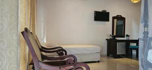a bedroom with a bed and a chair and a mirror at Surf Villa Hikkaduwa in Hikkaduwa