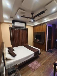 a bedroom with a bed with a ceiling fan at Mohar Residency Madhyamgram in kolkata +24 photos