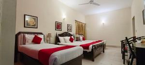a bedroom with two beds with red and white sheets at Herfa INN Hotel Lahore in Lahore