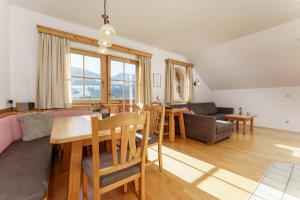 a living room with a table and a dining room at Kainreiterhof in Aich