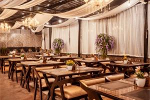 a restaurant with wooden tables and chairs and chandeliers at Sunoraa Luxury Hotel & Spa in Mussoorie