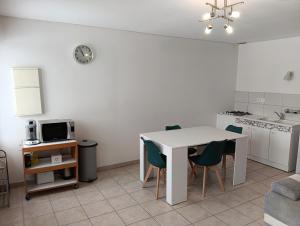 a kitchen and dining room with a table and chairs at Appartement rez-de-chaussée calme in Neuilly-lʼÉvêque