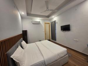 a bedroom with a bed and a flat screen tv at Devlok Homes in Rishīkesh