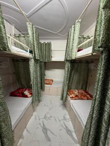 two bunk beds in a room with green curtains at Bunk House in Rishīkesh