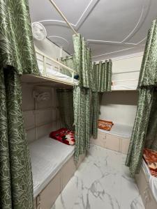a room with two bunk beds with green curtains at Bunk House in Rishīkesh