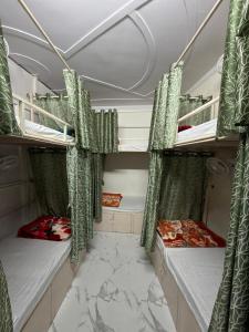 two bunk beds in a room with green curtains at Bunk House in Rishīkesh +1 photo