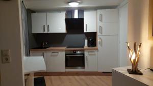 a kitchen with white cabinets and a counter top at Ferienwohnung Nordholland in Nieuwe-Niedorp +28 photos