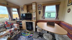 a living room with a couch and a table and a tv at Meadows nook in Clitheroe