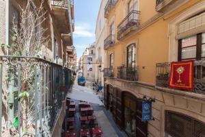 un callejón estrecho con edificios y carteles en los edificios en Estudios Muñoz, en Alicante