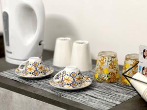 a table topped with three cups and a counter top with at Pompei Comfort Room in SantʼAntonio Abate