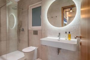 a bathroom with a sink and a toilet and a mirror at 224 Boutique Hostel in Sliema
