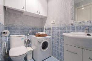 a bathroom with a toilet and a sink and a washing machine at Estudios Muñoz in Alicante +55 photos