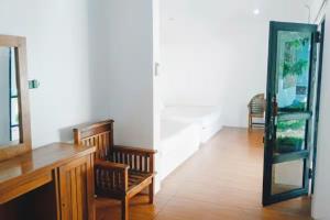 a hallway with a mirror and a chair in a room at La Plage Beach Club in Tjikakaka