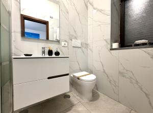 a white bathroom with a toilet and a mirror at Pompei Comfort Room in SantʼAntonio Abate