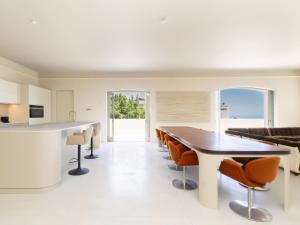 a kitchen and dining room with a table and chairs at Luxury 8-Suite Villa with Heated Pools, Ocean & Mountain Views in Cape Town