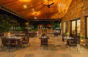a restaurant with tables and chairs on a patio at Anandam - A Luxury Resort in Udaipur in Udaipur