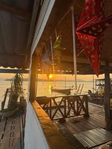 a porch with a table and a view of the ocean at Kaneng Homestaykohpu in Ban Klang