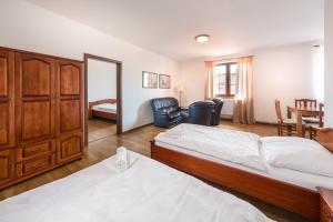 a bedroom with two beds and a chair and a table at Penzion Mušlov in Mikulov +82 photos