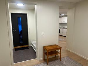 a hallway with a black door and a table at Nyoppusset leilighet i Vadsø in Vadsø