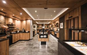a large kitchen with wooden walls and aasteryasteryasteryasteryasteryasteryasteryastery at VALARA Alpine Art Hotel in Tux