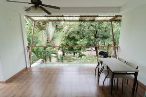 a dining room with a table and a ceiling fan at Baan Suan Khun Ta and Golf Resort in Ubon Ratchathani