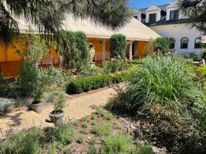 a garden in front of a house with plants at Złote Runo - Kameralny hotelik & Restauracja in Karolina +32 photos