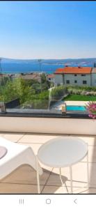 a white chair and a table and a view from a balcony at Villa Superior Two in Crikvenica