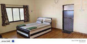 a small bedroom with a bed in a room at Silver sand beach resort in Malvan