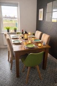 a dining room table with chairs and a table with candles at Sunset House On The Beach in Maryport