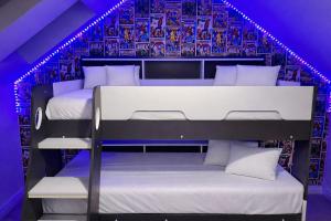 two bunk beds in a room with purple lights at Sunset House On The Beach in Maryport