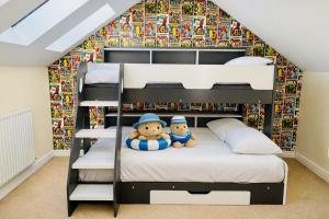 two teddy bears sitting on a bunk bed in a room at Sunset House On The Beach in Maryport