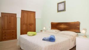 a bedroom with a bed with blue slippers on it at Casa Lucia in Specchia
