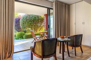 ein Esszimmer mit Tisch und Stühlen und einem großen Fenster in der Unterkunft Botleng Guest House in Maseru