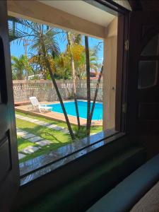 a window view of a swimming pool from a house at Praia do fort in Camacari