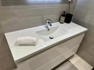 a bathroom with a white sink and a bath tub at Nordic Comfort Suite with Hot Tub in Storeidet +15 photos