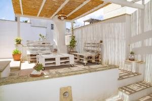 a porch with two chairs and a wooden roof at Casa Lucia in Specchia