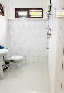 a white bathroom with a toilet and a sink at S70 Villa in Dickwella