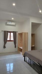 a bedroom with a bed and a window in it at Apartamentos de Metiaut in Dili