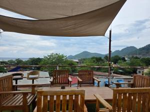 a deck with chairs and tables and an umbrella at Apartamentos de Metiaut in Dili