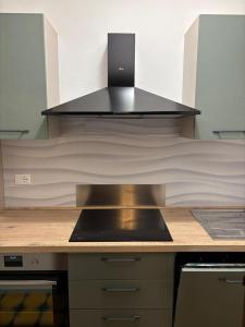 a kitchen with a stove and a hood over a counter at Appartamento Aprica 2.0 in Aprica